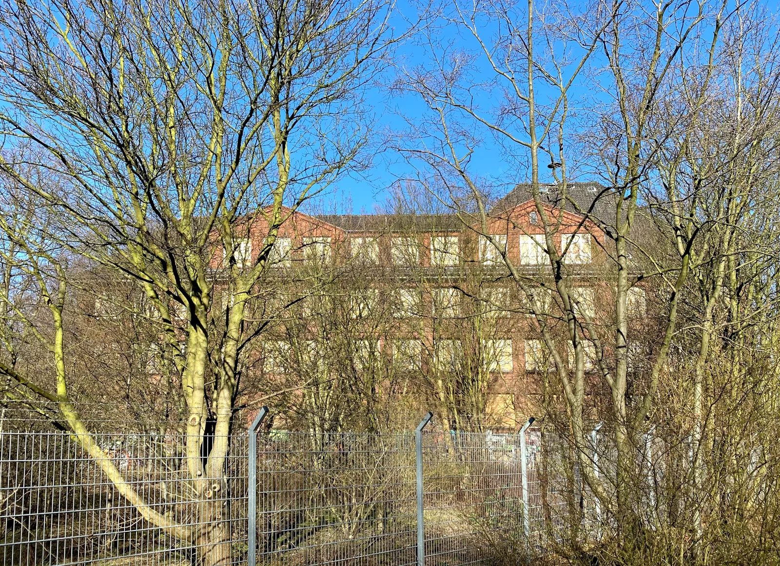 The empty brick school on Neuhöfer Damm in Hamburg-Wilhelmsburg with boarded-up windows