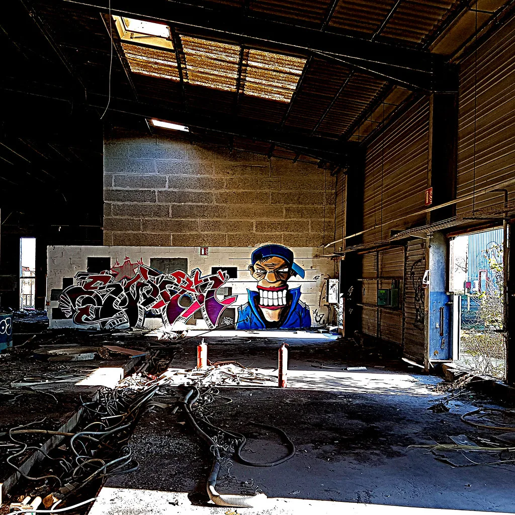 Inside the abandoned Authion foundry at Les Ponts-de-Ce: rusted roof, graffiti and rubble