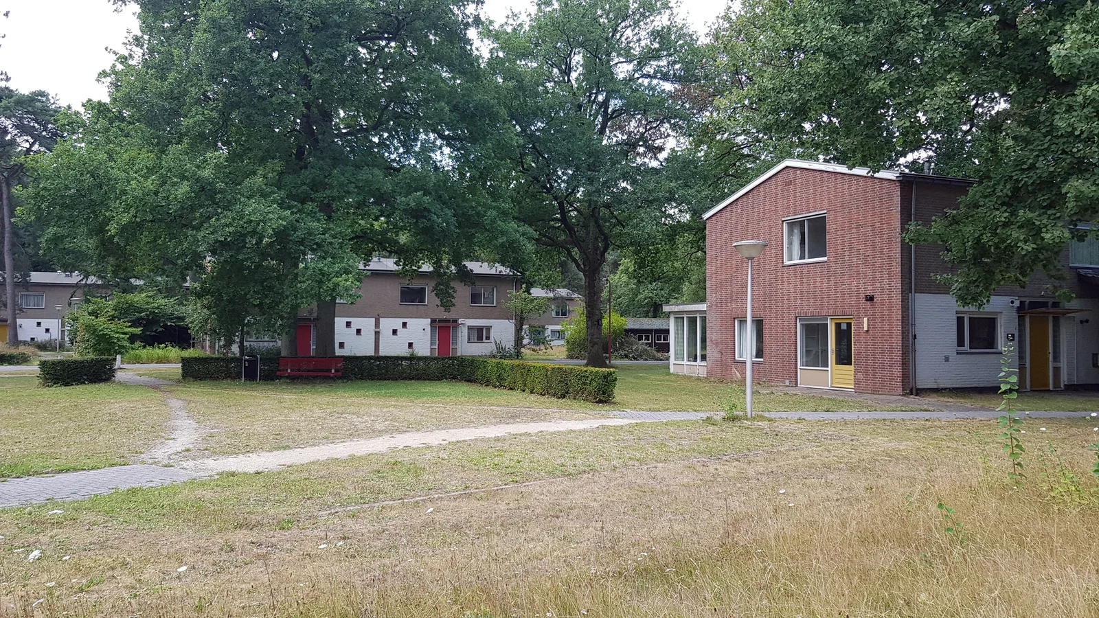 Empty buildings on the wooded Pro Persona site in Wolfheze, abandoned pavilions amid the tall grass