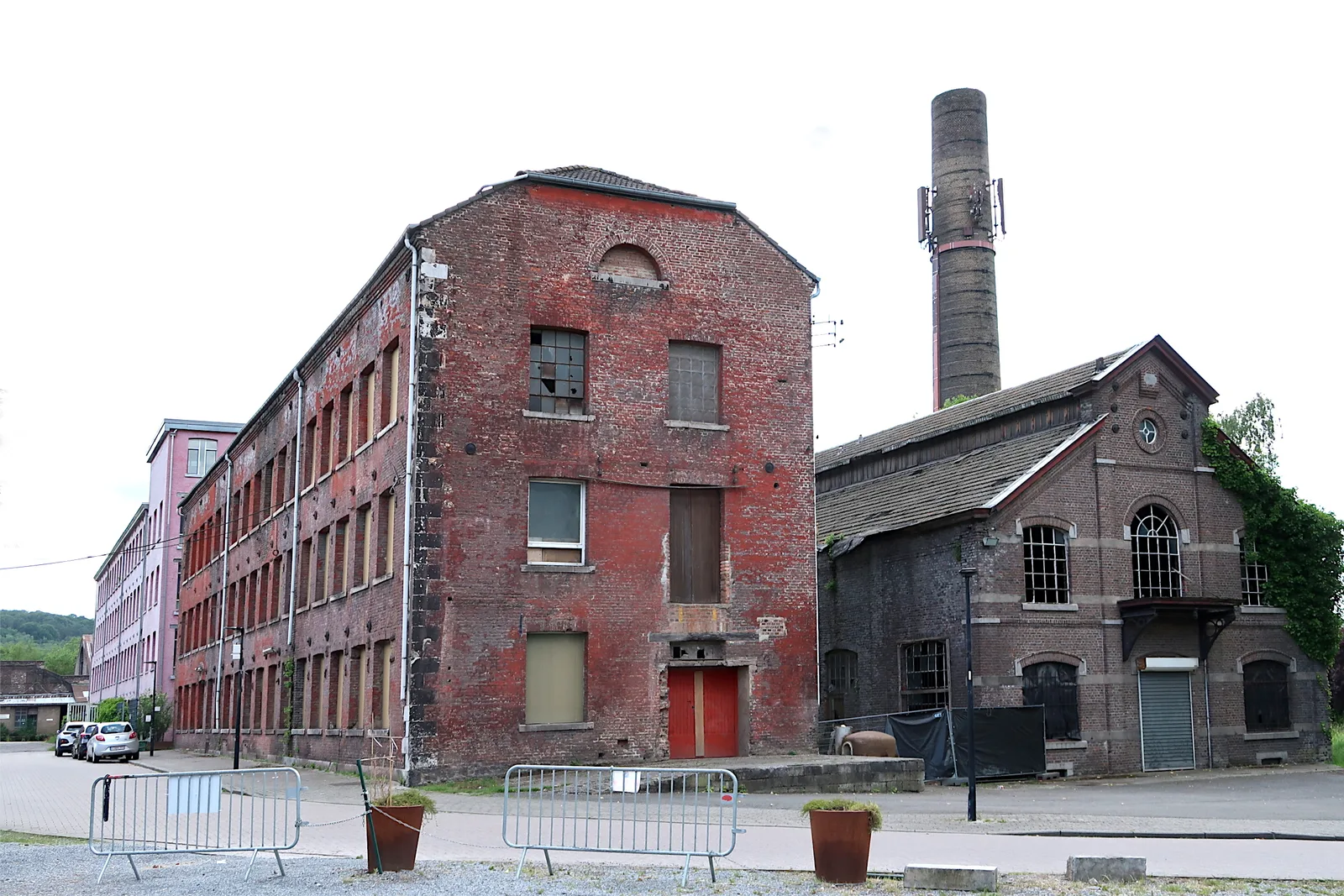 Abandoned industrial buildings of the Val Saint-Lambert crystalworks in Seraing, brick walls and a chimney