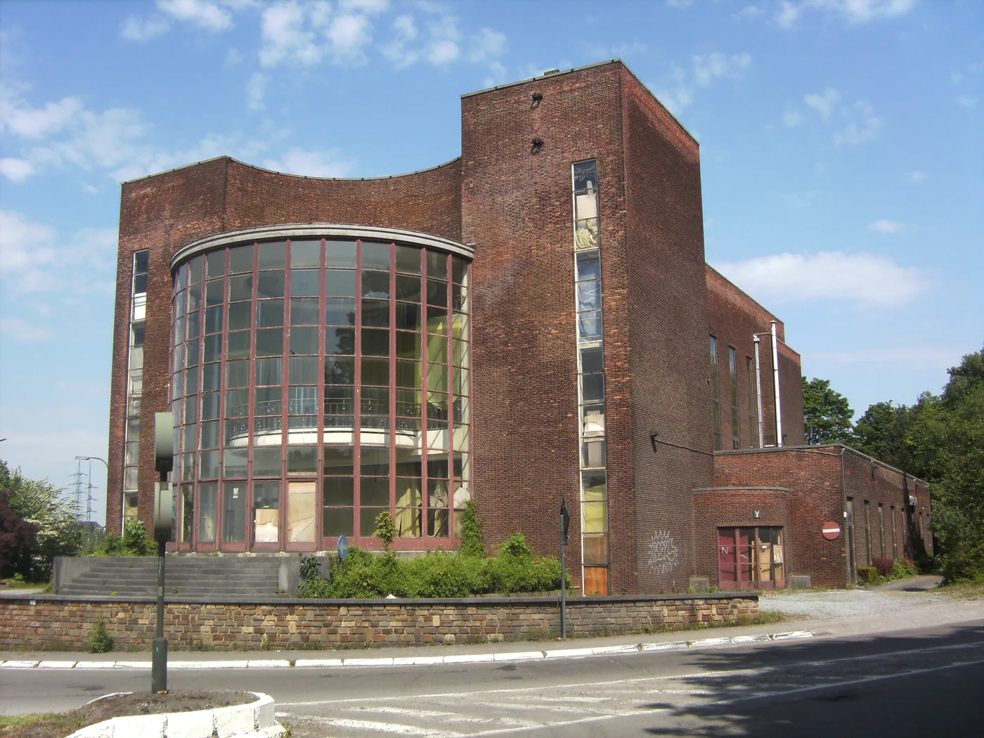 The brick facade and glazed rotunda of the abandoned Amicale Solvay in Couillet, Charleroi