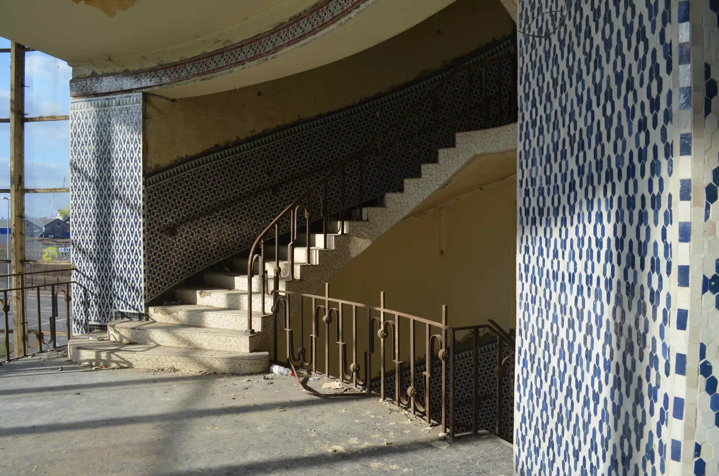 The terrazzo staircase and blue tiles of the rotunda of the abandoned Solvay swimming pool